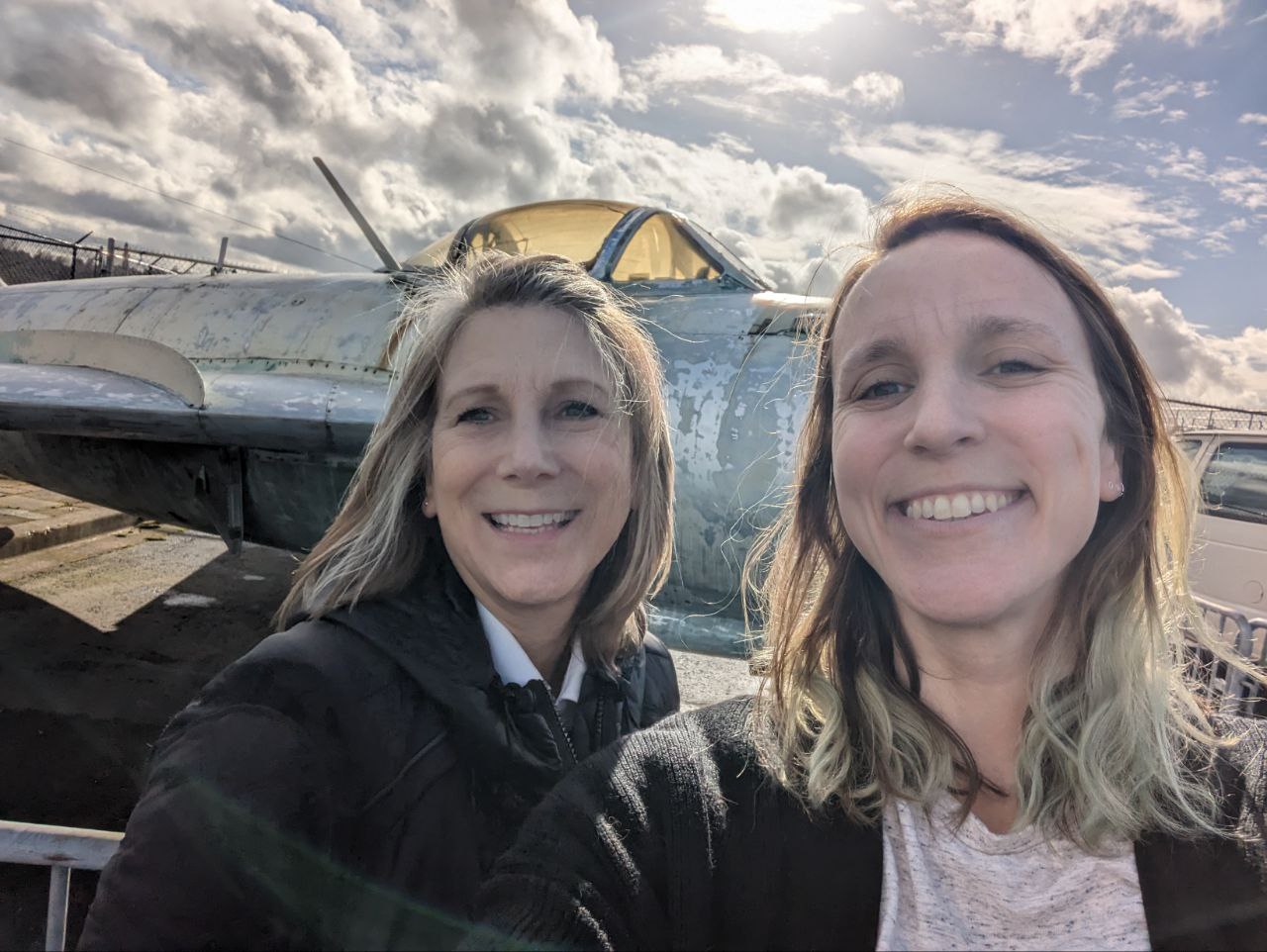 Kay and Denise selfie in front of a aircraft display at the Museum of Flight.